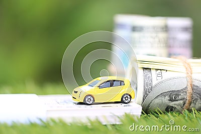 Miniature yellow car model with dollas banknotes on nature green background, Saving money for car, Finance and car loan, Stock Photo