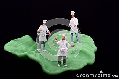 Miniatures of chef and salad leaf Stock Photo