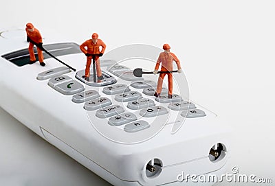 Miniatures of workers fixing a cordless phone Stock Photo