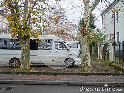 Minibuses at the old house. Yard in Batumi. Parked vehicles Stock Photo