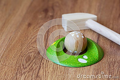 Minigolf wood for kids. Golf club and a ball during a mini golf game. Children`s Games at Home Stock Photo