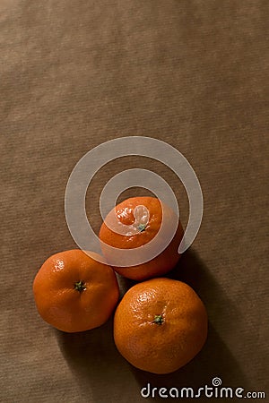 Minimal composition - Three clementines on brown paper Stock Photo