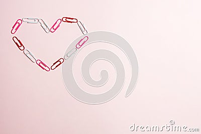 Minimal concept. Heart symbol made of stationery clips on pink background. Flat lay, top view Stock Photo