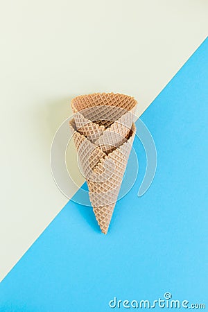 Two empty ice cream cones on half yello half blue pastel background. Minimal creative concept. Stock Photo