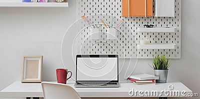 Minimal home office with open blank screen laptop computer with stationary Stock Photo
