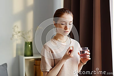 Young Woman Taking Vitamin Supplements Stock Photo