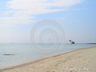 Minimalism, Seclusion & Isolation - Vastness of Ocean with a Tree in Water at a distance on White Sandy Beach - Natural Background Stock Photo