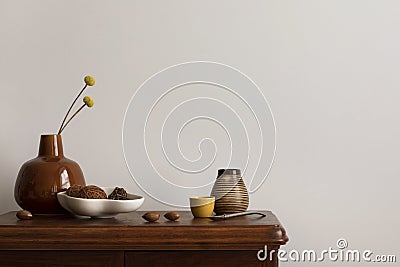 Minimalist composition of living room interior with copy space, wooden commode, stylish vase with dried flowers, bowl with coconut Stock Photo