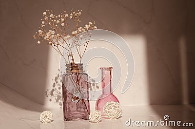 Modern still life with a glass vase, decorative gypsophila flowers and a balls. Stock Photo