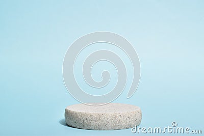 Minimalistic scene of a lying stone on a light blue background. Podium for the presentation of goods and cosmetics. A Stock Photo