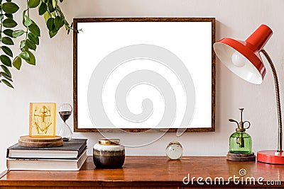 Minimalistic and stylish mock up poster frame concept with retro furnitures, hanging plant, table lamp, decoration. Stock Photo