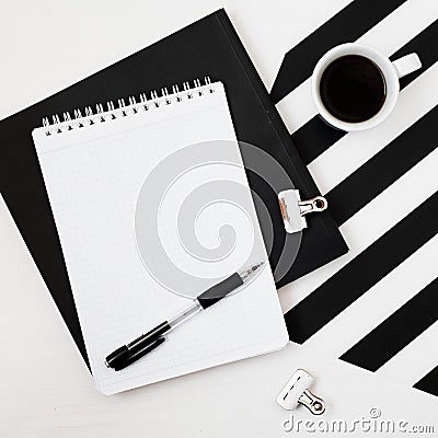 Minimalistic workspace with book, notebook, pencil, cup of coffee on striped black and white background. Flat lay style Top view Stock Photo