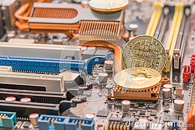 Mining btc crypto cash. Two bitcoin on radiator of desktop computer mainboard Stock Photo