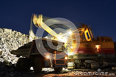 Mining. excavator loading granite or ore into dump truck Stock Photo