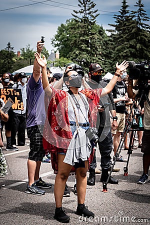 Black Lives Matter protestor lifting hands in prayer for George Floyd Family Memorial Service after Minneapolis riots Editorial Stock Photo