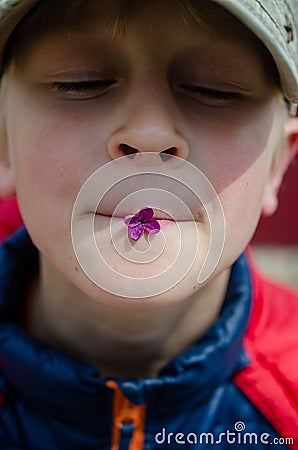 A minor child sniffs a bouquet of lilacs. Stock Photo