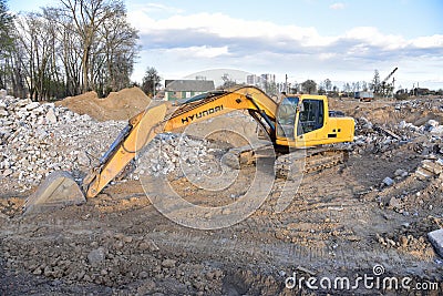 Excavator HYUNDAI work at landfill with concrete demolition waste. Salvaging and recycling building and Editorial Stock Photo