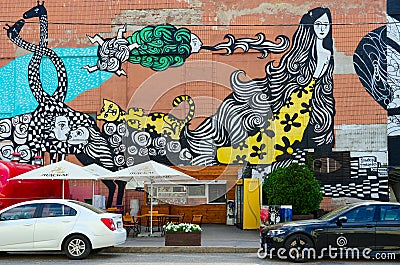 Street art on Oktyabrskaya street. Graffiti mermaid, cat, giraffes, roses, kiss on wall of industrial building, Minsk, Belarus Editorial Stock Photo