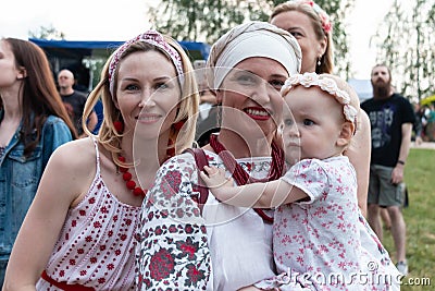 Minsk. Belarus. 08.12.2022. Beautiful smiling women in national Slavic Belarusian ethnic costumes with a baby in her arms. Feast Editorial Stock Photo