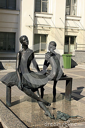 A very beautiful statue of two ballerinas dressed in tutu skirts sitting on a bench on the street Editorial Stock Photo