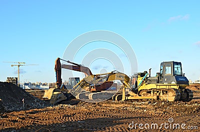 Bulldozer Shantui SD16 and Group Excavators brands of the Kraneks and CATERPILLAR with buckets Editorial Stock Photo