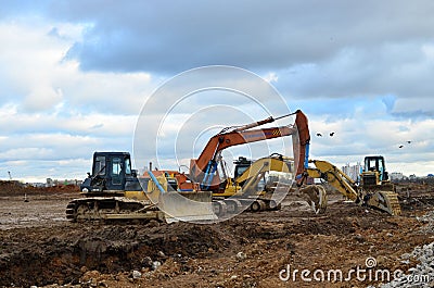 Bulldozer Shantui SD16 and Group Excavators brands of the Kraneks and CATERPILLAR with buckets on a Editorial Stock Photo