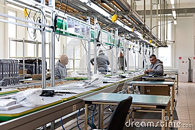 Minsk, Belarus - Dec 15, 2021: Photo of a plant for assembling monoblocks for computers. Working men work on a conveyor Editorial Stock Photo