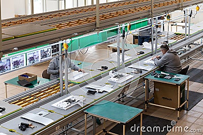 Minsk, Belarus - Dec 15, 2021: Photo of a plant for assembling monoblocks for computers. Working men work on a conveyor Editorial Stock Photo