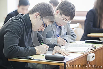 Teenage boys making notes in their exercise books Editorial Stock Photo