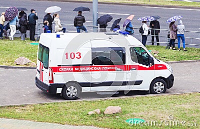 MINSK, BELARUS - JULY 3, 2018: A modern ambulance car is in the city, there are people with umbrellas, rain Editorial Stock Photo