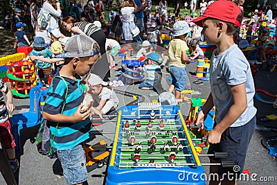 Minsk, Belarus, June 3, 2018: Children play table football on playground with a lot of children, parents and toys in city outdoors Editorial Stock Photo