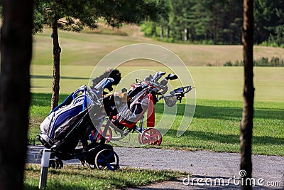 Minsk. Belarus - 24.07.2021 - Push-Pull Golf Carts. Green grass, trees. Editorial Stock Photo