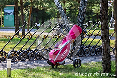 Minsk. Belarus - 24.07.2021 - Push-Pull Golf Carts. Green grass, trees. Editorial Stock Photo