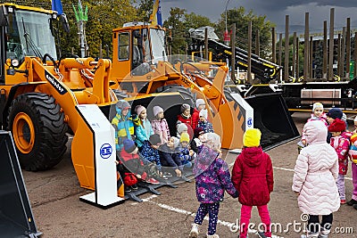 Minsk, Belarus, September 20, 2022: Children pose in a forklift bucket, a new forklift is on display Editorial Stock Photo