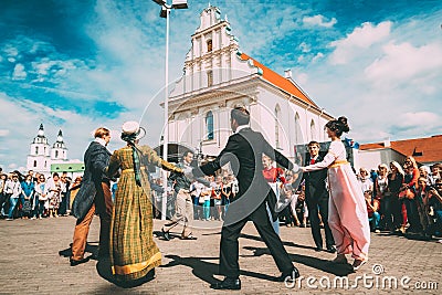 Minsk, Belarus. Couple of people dressed in clothes of the 19th century dancing Polonaise at the celebration of the Day Editorial Stock Photo