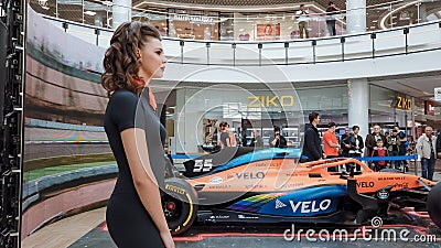 Editorial. McLaren racing car bolide exhibition. Beautiful girl agent on racing car display exhibition. Crowd of people. Editorial Stock Photo