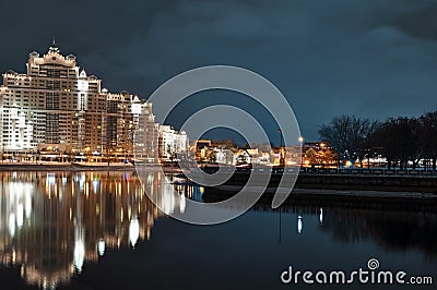 Minsk city nightly landscape with reflection in Svislach river in the evening. Night scene of Trinity hill, downtown Nemiga, Nyami Stock Photo