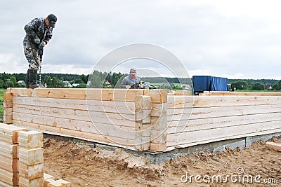 Minsk Region. Belarus. February 24, 2016. Workers drill holes for driving Nagel. construction of bony from natural wood Editorial Stock Photo