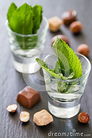 Mint in glass cups, chocolate, nuts Stock Photo