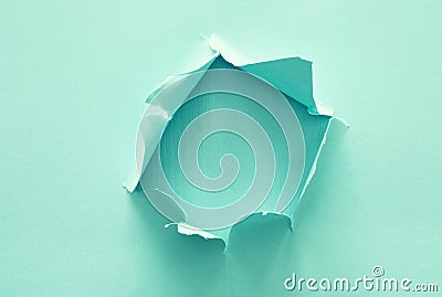 Mint pastel color background with hole in the paper. Copy space. Stock Photo