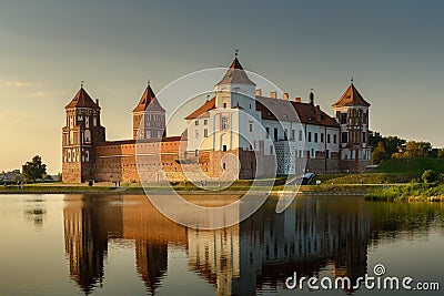 Mir Castle, Belarus. Scenic panoramic view of the complex across the pond with reflections on the water in the evening twilight. Stock Photo