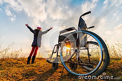 Miracle recovery II: young girl gets up from wheelchair and raises hands up Stock Photo