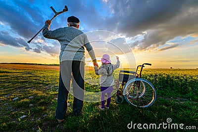 Miracle recovery: Old man gets up from wheelchair and raises hands up Stock Photo