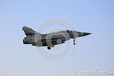 A Mirage 2000 flying in the sky on a hazy day and landing. Editorial Stock Photo