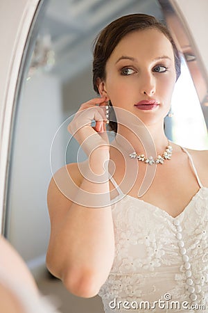 Mirror with reflection of beautiful bride wearing earring Stock Photo