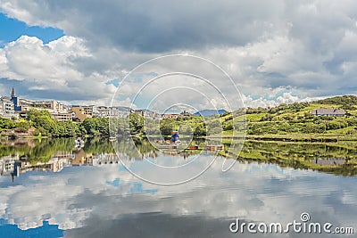 Mirror reflection in the port of Clifden at high tide and the village in the background Stock Photo