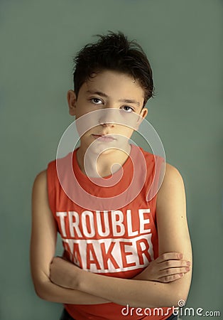 Mischievous teenager boy in trouble maker t-shirt close up sad portrait Stock Photo