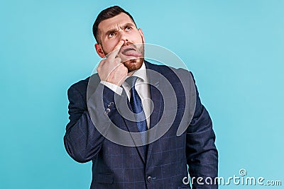 Misconduct, bad manners. Funny man wearing official style suit picking nose and sticking out tongue Stock Photo