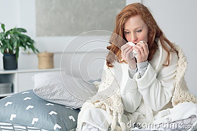 Miserable woman blowing runny nose Stock Photo