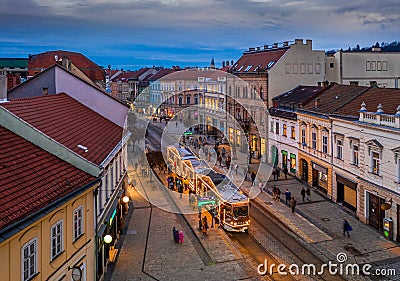 Miskolc, Hungary - Festively decorated Christmas light tram and traditional houses at the high-street of Miskolc, Borsod county Stock Photo